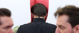 Der Angeklagte steht in einem Gerichtssaal des Landgerichtes in der Anklagebank zwischen seinen Anwälten Philip Müller (l) und Alexander Stevens. 