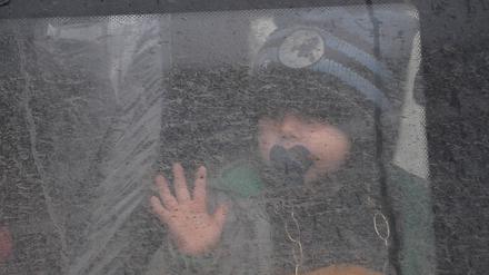 Ein Kind schaut am 20. April 2022 am Kontrollpunkt Verigovka-Chugunovka in der Region Belgorod (Russland) aus dem Fenster eines Busses.