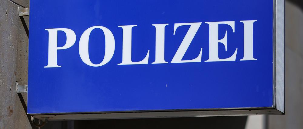 Ein Schild mit der Aufschrift „Polizei“ hängt an einem Polizeirevier i Leipzig.