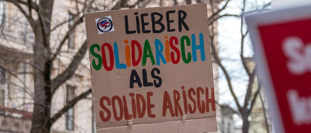 19.03.2024, Brandenburg, Cottbus: «Lieber solidarisch statt solide arisch» steht auf einem Plakat, das ein Teilnehmer einer Demonstration mit sich führt. Die Initiative für Vielfalt und Toleranz rief zur Teilnahme an der Demonstration für eine offene Gesellschaft auf. Anlass ist eine Veranstaltung der Cottbuser AfD, auf der der fraktionslose Bundestagsabgeordnete Helferich auftreten soll. Mehrere demokratische Organisationen aus der Region beteiligen sich am Aufruf zu der Demonstration. Foto: Frank Hammerschmidt/dpa +++ dpa-Bildfunk +++