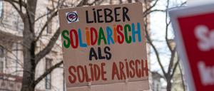 19.03.2024, Brandenburg, Cottbus: «Lieber solidarisch statt solide arisch» steht auf einem Plakat, das ein Teilnehmer einer Demonstration mit sich führt. Die Initiative für Vielfalt und Toleranz rief zur Teilnahme an der Demonstration für eine offene Gesellschaft auf. Anlass ist eine Veranstaltung der Cottbuser AfD, auf der der fraktionslose Bundestagsabgeordnete Helferich auftreten soll. Mehrere demokratische Organisationen aus der Region beteiligen sich am Aufruf zu der Demonstration. Foto: Frank Hammerschmidt/dpa +++ dpa-Bildfunk +++