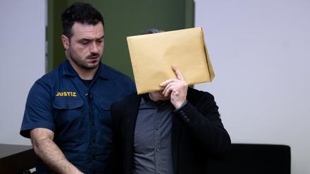 Der wegen des Besitzes und der gewerbsmäßigen Verbreitung kinder- und jugendpornografischer Schriften Angeklagte (r) wird vor Prozessbeginn am Landgericht in den Gerichtssaal geführt.
