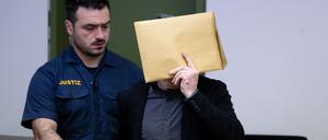 Der wegen des Besitzes und der gewerbsmäßigen Verbreitung kinder- und jugendpornografischer Schriften Angeklagte (r) wird vor Prozessbeginn am Landgericht in den Gerichtssaal geführt.