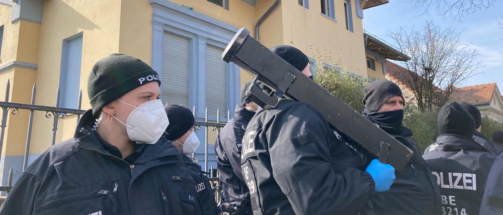 Ein Polizist steht vor dem beschlagnahmten Haus des Remmo-Clans mit einem Tür-Rammen bereit.