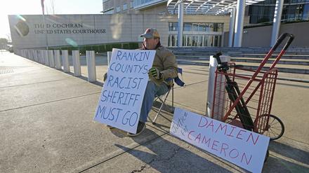 62, aus Jackson, sitzt vor dem Thad Cochran United States Courthouse in mit Plakaten Unterstützung für die beiden Männer, die von damals Vollzugsbeamten des Mississippi Rankin County misshandelt wurden. 