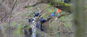 Ein Taucher der Polizei sucht in einem Gewässer nach der Leiche einer mutmaßlich getöteten Frau.