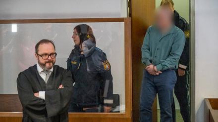 Der Angeklagte (r) wird in den Gerichtssaal geführt. Der Rechtsanwalt des Angeklagten, Maximilian Siller (l), steht an seinem Platz. (Archivbild)