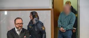 Der Angeklagte (r) wird in den Gerichtssaal geführt. Der Rechtsanwalt des Angeklagten, Maximilian Siller (l), steht an seinem Platz. (Archivbild)