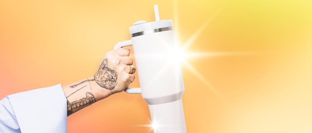 Tätowierte Hand hält einen Stanley-“Quencher“.