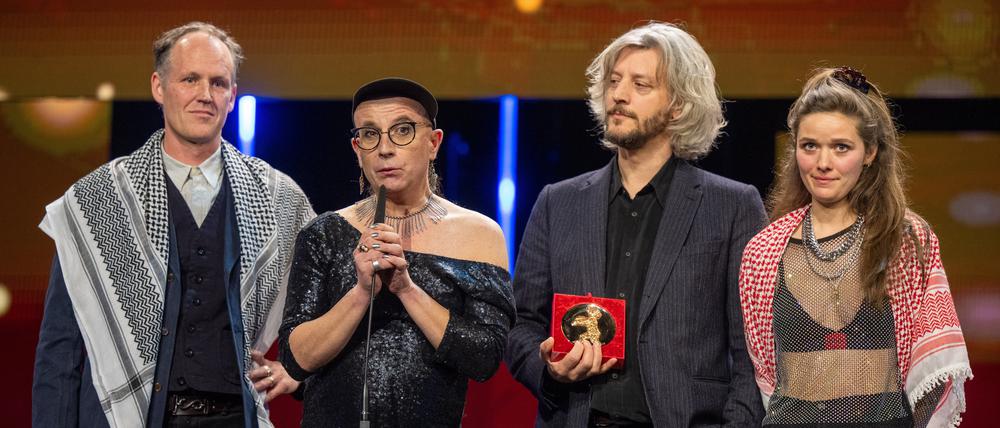 Ben Russell (l) und Servan Decle (r) tragen Palästinensertücher bei der Abschlussgala im Berlinale Palast auf der Bühne, während sie zusammen mit Jay Jordan (2.v.l) und Guillaume Cailleau, nachdem sie für den Film ·Direct Action· den Encounters Preis für den Besten Film gewonnen haben.