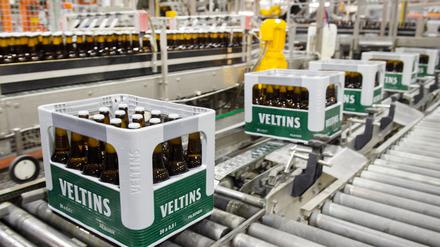 Bierkästen und im Hintergrund Bierflaschen bewegen sich durch die Produktion der Veltins-Brauerei in Meschede-Grevenstein (Nordrhein-Westfalen) über die Förderbänder einer Befüllungsanlage. 