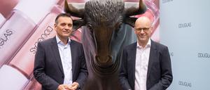 Sander van der Laan (l), CEO von Douglas und Finanzchef (CFO) Mark Langer stehen beim Börsengang der Douglas AG vor der Börse an der Bullen-Skulptur. 