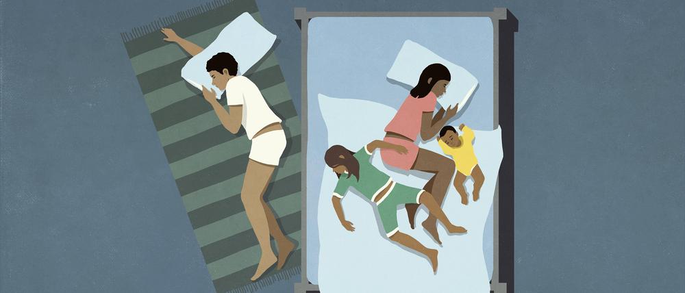 Ein Vater schläft neben der Familie auf dem Boden.