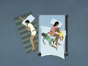 Ein Vater schläft neben der Familie auf dem Boden.