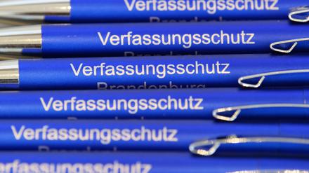Blaue Kugelschreiber mit dem Aufdruck „Verfassungsschutz“ liegen im Innenministerium von Brandenburg auf einem Tisch. 