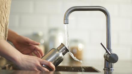 Eine Frau füllt eine Wasserflasche (Symbolbild).