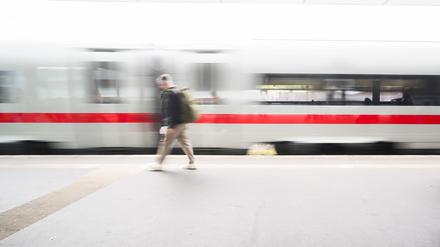 Ein Mann läuft auf einem Bahnsteig im Hauptbahnhof Hannover, während ein ICE einfährt.