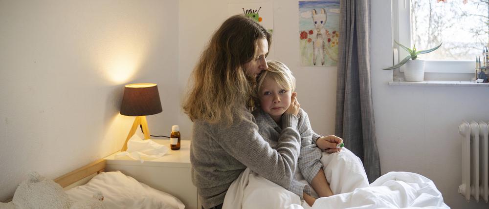 Mother pampering son with fever sitting on bed at home model released, Symbolfoto property released, NJAF00777 krank2203