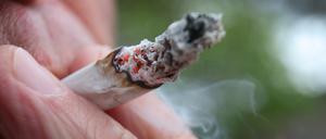 Ein Mann raucht einen Joint. 