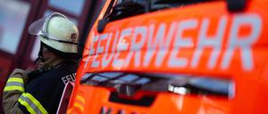 ILLUSTRATION - 08.11.2023, Baden-Württemberg, Stuttgart: Eine Einsatzkraft der Feuerwehr steht während eines Pressetermins neben einem Einsatzfahrzeug der Feuerwehr (gestellte Szene). (zu dpa: «Zwei Schwerverletzte nach Frontalzusammenstoß in der Pfalz») Foto: Marijan Murat/dpa +++ dpa-Bildfunk +++