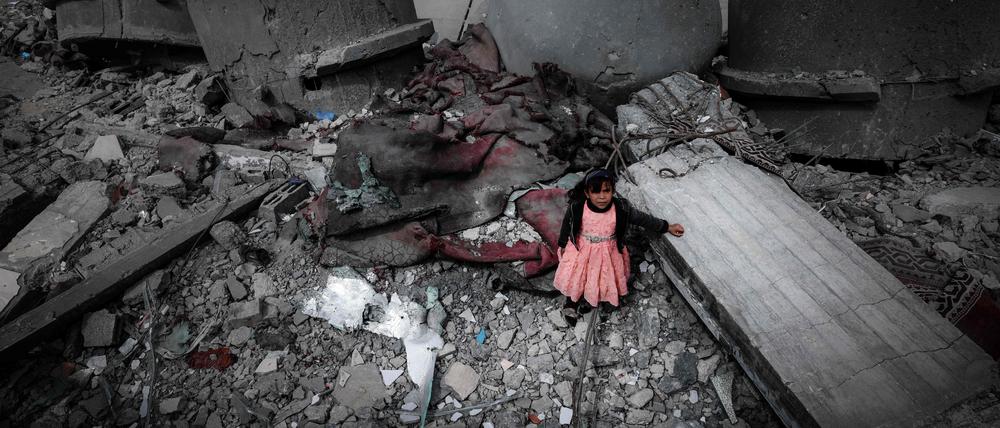 Ein palästinensisches Mädchen in einem rosa Kleid steht inmitten der Ruinen der Al-Faruq-Moschee, die während der israelischen Bombardierung in Rafah Mitte März zerstört wurde.