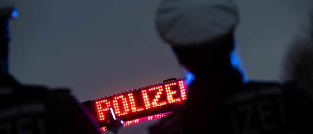 ARCHIV - 30.11.2023, Baden-Württemberg, Stuttgart: Zwei Polizisten stehen im Rahmen eines Fototermins vor einem Polizeifahrzeug (gestellte Szene). (zu dpa: «Zwei 17-Jährige wegen Freiheitsberaubung in Untersuchungshaft») Foto: Marijan Murat/dpa +++ dpa-Bildfunk +++