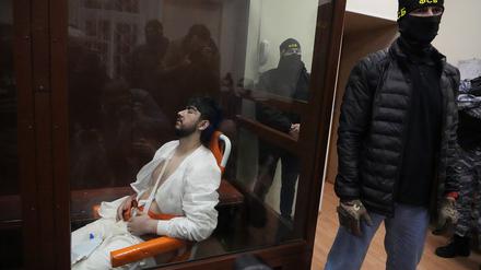 Ein Tatverdächtiger ist offenbar so verletzt, dass er den Vorgängen im Gericht  anscheinend gar nicht folgen kann. 