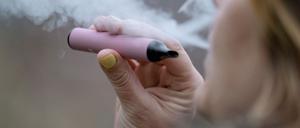 Eine Frau raucht eine E-Zigarette.