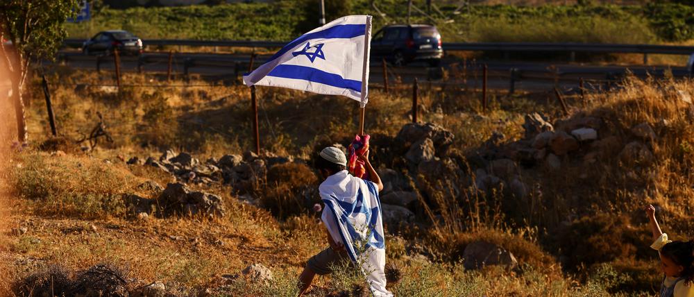Ein Junge mit Israelflaggen demonstriert für die Gründung einer neuen Siedlung nahe Hebron im Westjordanland.