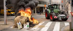 Bei Protesten anlässlich eines Treffens der EU-Agrarminister in Brüssel zünden Landwirte Strohballen an.