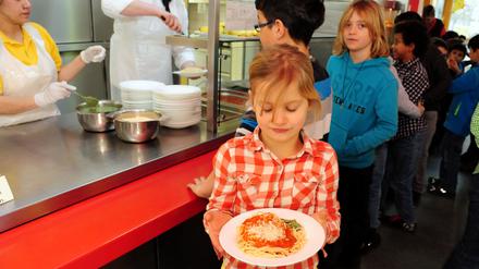 Elena holt ihr Essen. Es gibt – Überraschung! – Spaghetti mit Tomatensoße und Pesto in der Mensa der Heinrich-Zille-Schule in Kreuzberg Foto.