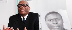 Mutombo Mansamba, sitzt hinter einem Bild seines gestorbenen Bruders Kupa Ilunga Medard Mutombo, bei einer Pressekonferenz in der Beratungsstelle ReachOut zum Fall von Kupa Ilunga Medard Mutombo, der drei Wochen nach einem Polizeieinsatz ums Leben kam.