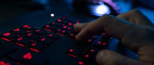 Ein Mann sitzt am Rechner und tippt auf einer Tastatur.