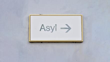 ARCHIV - 04.08.2014, Baden-Württemberg, Karlsruhe: Ein Schild mit der Aufschrift «Asyl» hängt in Erstaufnahme für Asylbewerber an einer Wand. (zu dpa: «Weniger Flüchtlinge in kommunalen Unterkünften») Foto: Uli Deck/dpa +++ dpa-Bildfunk +++