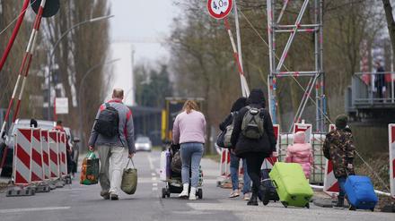 Ukrainische Flüchtlinge verlassen mit ihrem Gepäck eine Flüchtlingsunterkunft. (Symbolbild)