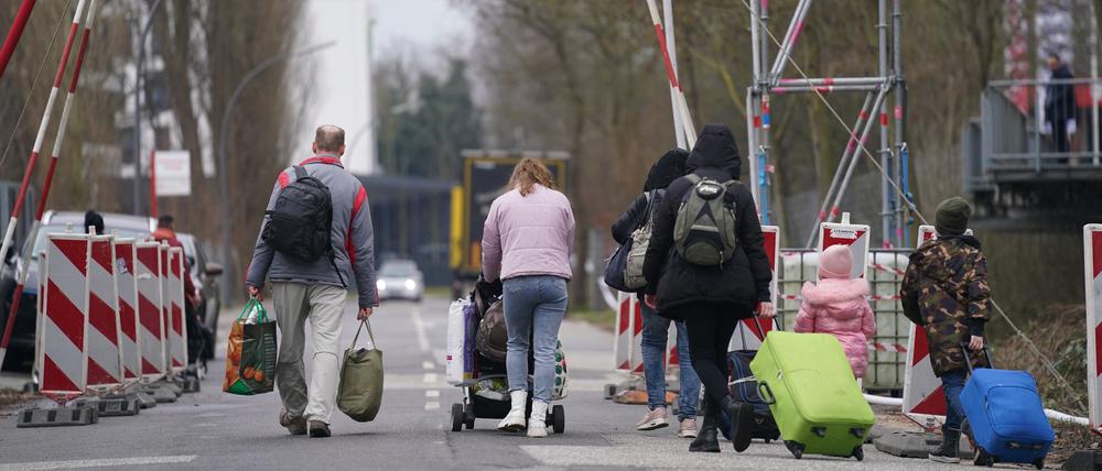 Ukrainische Flüchtlinge verlassen mit ihrem Gepäck die Flüchtlingsunterkunft im ehemaligen Fegro Großmarkt im Stadtteil Harburg (Archivbild).