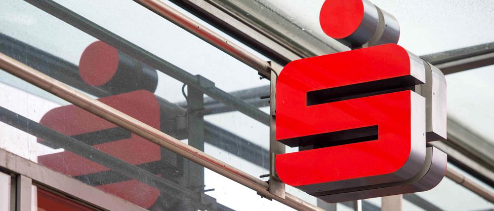 Ein Sparkassenlogo hängt an der Fassade einer Berliner Sparkassen-Filiale.
