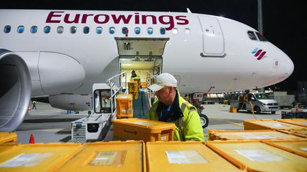 Ein Airbus A320-214 der Fluggesellschaft Eurowings mit Ziel Stuttgart wird auf dem Flughafen Berlin Brandenburg (BER) mit Plastikboxen voller Briefe und anderer Post beladen.