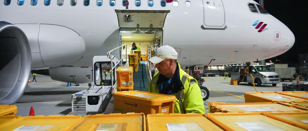 Ein Airbus A320-214 der Fluggesellschaft Eurowings mit Ziel Stuttgart wird auf dem Flughafen Berlin Brandenburg (BER) mit Plastikboxen voller Briefe und anderer Post beladen.