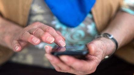 ARCHIV - 06.03.2018, Baden-Württemberg, Mühlacker: Eine Seniorin tippt auf ihrem Smartphone. Kriminelle wollen sich mit dem sogenannten Enkeltrick Geld ergaunern. (zu dpa: «Trickbetrüger ergaunern 2023 rund 4,4 Millionen Euro in Thüringen») Foto: Sebastian Gollnow/dpa +++ dpa-Bildfunk +++