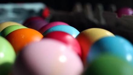 Bunt bemalte Eier liegen dicht an dicht.