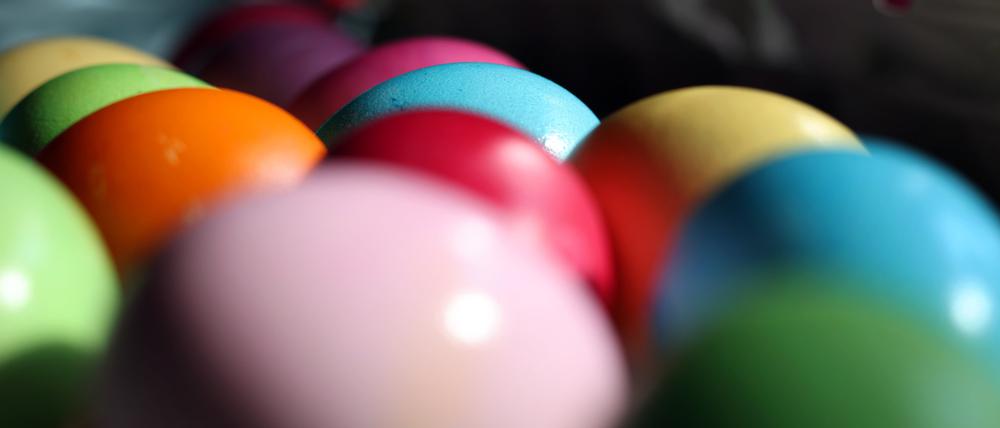 Bunt bemalte Eier liegen dicht an dicht.