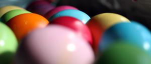Bunt bemalte Eier liegen dicht an dicht.