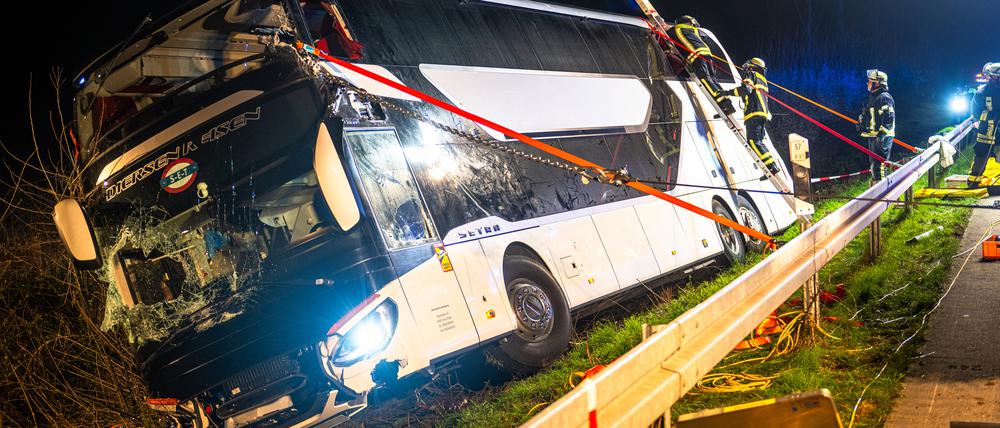 Einsatzkräfte der Feuerwehr arbeiten an einer Unfallstelle auf der Autobahn 44 an dem verunfallten Bus. 