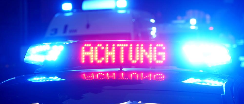 „Achtung“ ist auf dem Dach eines Polizeiautos zu lesen.