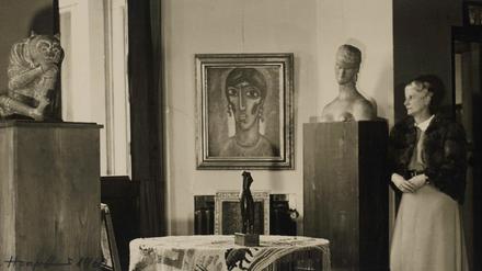Hanna Bekker vom Rath 1946 mit Teilen ihrer Sammlung, darunter der antike chinesische Flussgeist, ein Bildnis von Alexej von Jawlensky, die gewebte Tischdecke von Ida Kerkovius mit einer Kleinskulptur von Alexander Archipenko darauf und eine Büste von Wilhelm Lehmbruck. 