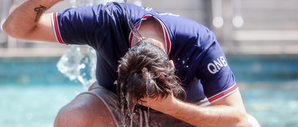 Ein junger Mann übergießt sich mit einer Wasserflasche, um die Hitze zu bekämpfen. Der vergangene Sommer ist nach Auswertungen des EU-Klimawandeldienstes Copernicus der wärmste bisher gemessene in Europa gewesen. 