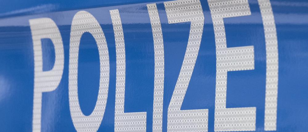 Der Schriftzug ·Polizei· ist auf einem Streifenwagen zu lesen.
