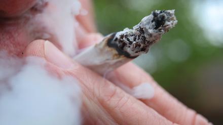 Ein Mann raucht einen Joint.