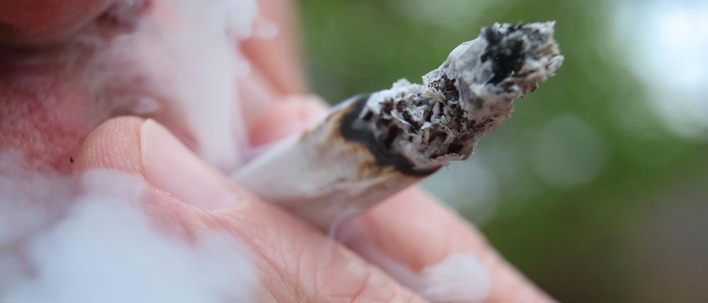 Ein Mann raucht einen Joint.